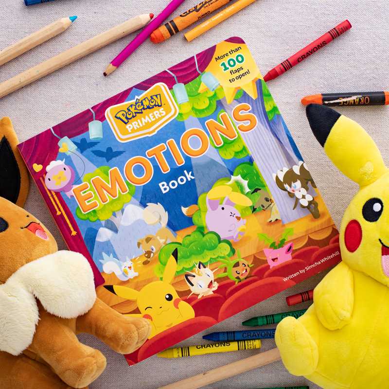 Pokémon Emotions book surrounded by toys and crayons on a textured surface