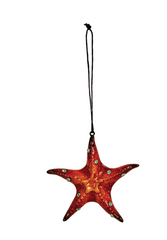 Red resin starfish ornament with jewel accents and hanging cord for coastal or holiday décor.
