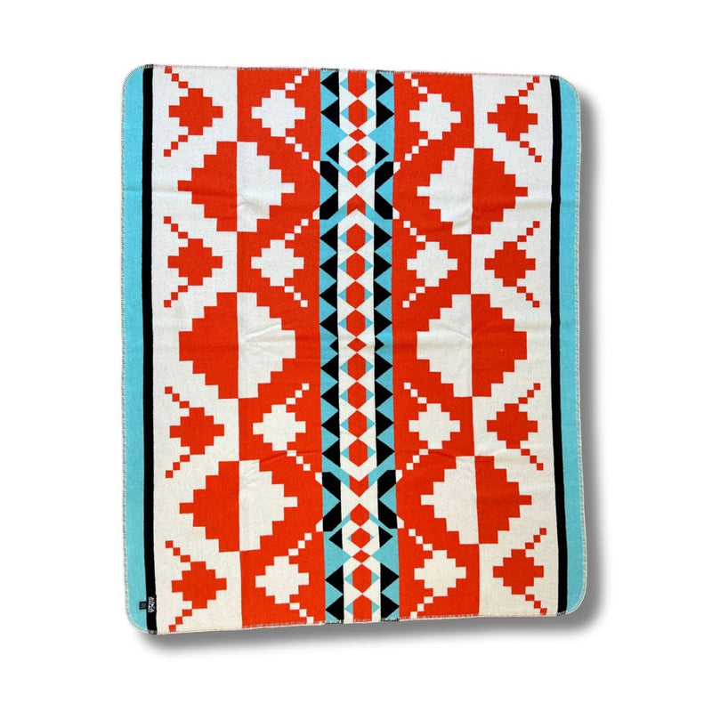 Folded corner view of the Red/White/Orange geometric alpaca blanket variant, showing the repeating motifs.