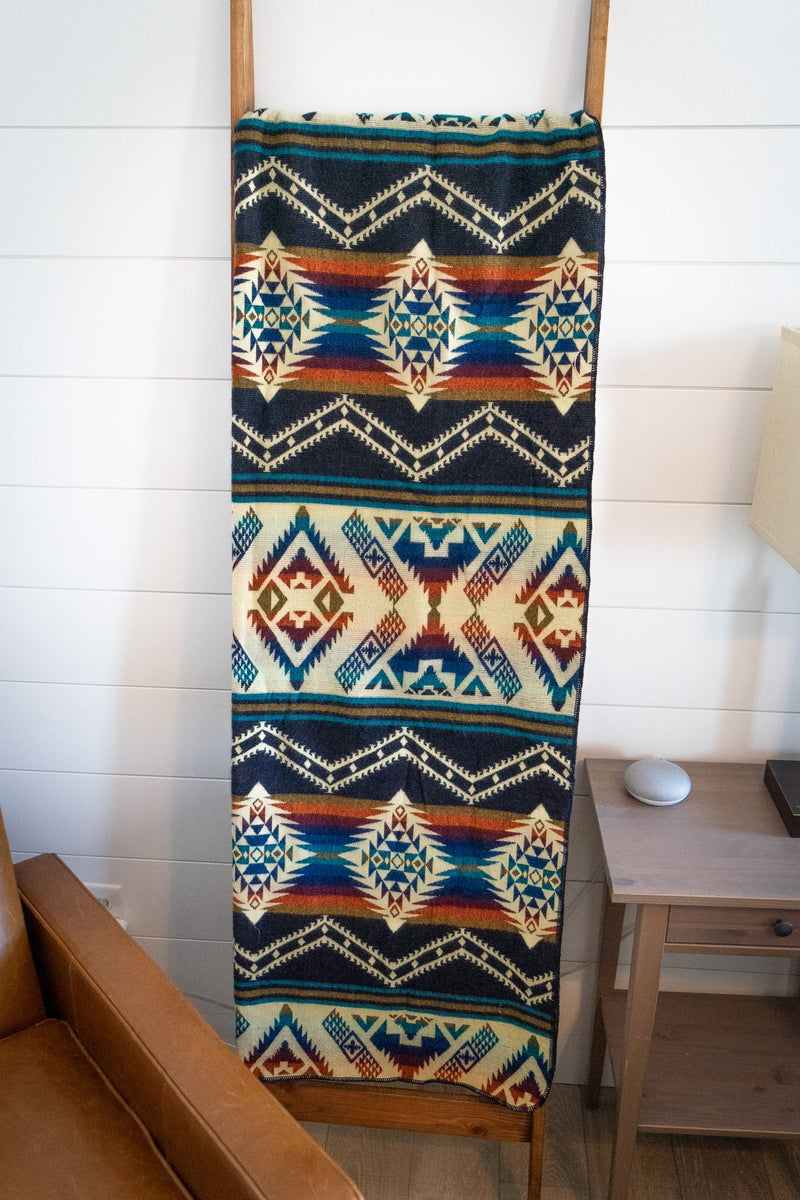 Angled close-up of the Rio blanket showing the dense pattern and rich colors near the folded corner.