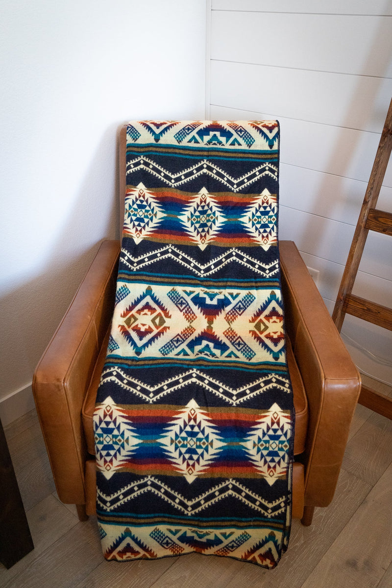Rio Alpaca Blanket folded vertically and standing upright on a light wooden chair, displaying the pattern length.