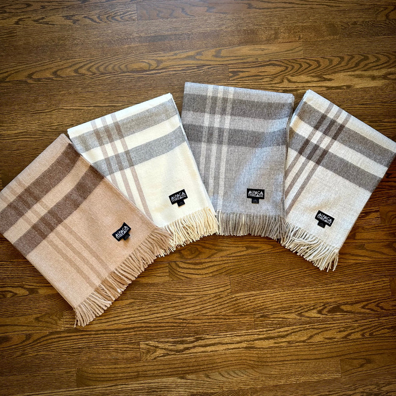Set of four royal baby alpaca wool checkered throw blankets in brown, cream, dark grey, and light grey tones – premium coastal home décor accent