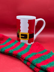Red and white Santa belt mug paired with red and green striped fuzzy socks on red backdrop.