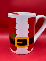 Close-up of Santa suit design ceramic mug featuring red body and black belt detail.
