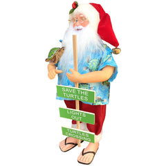 Side angle of Santa figurine showing blue Hawaiian shirt, red shorts, and sea turtle detail