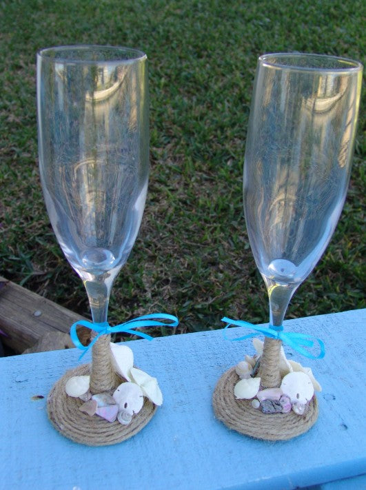 Rustic beach wedding champagne glasses decorated with twine, heart shells, sand dollars, starfish, and aqua ribbon bows