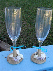 Rustic beach wedding champagne glasses decorated with twine, heart shells, sand dollars, starfish, and aqua ribbon bows