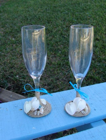 Rustic beach wedding champagne glasses decorated with twine, heart shells, sand dollars, starfish, and aqua ribbon bows