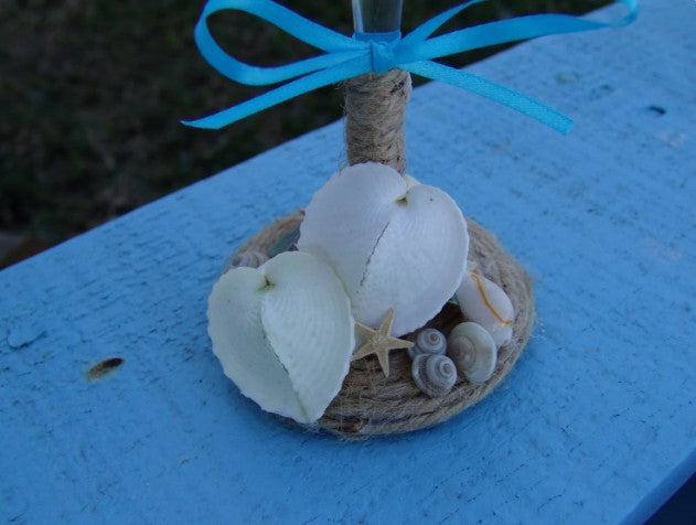 Rustic beach wedding champagne glasses decorated with twine, heart shells, sand dollars, starfish, and aqua ribbon bows