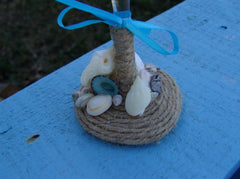 Rustic beach wedding champagne glasses decorated with twine, heart shells, sand dollars, starfish, and aqua ribbon bows