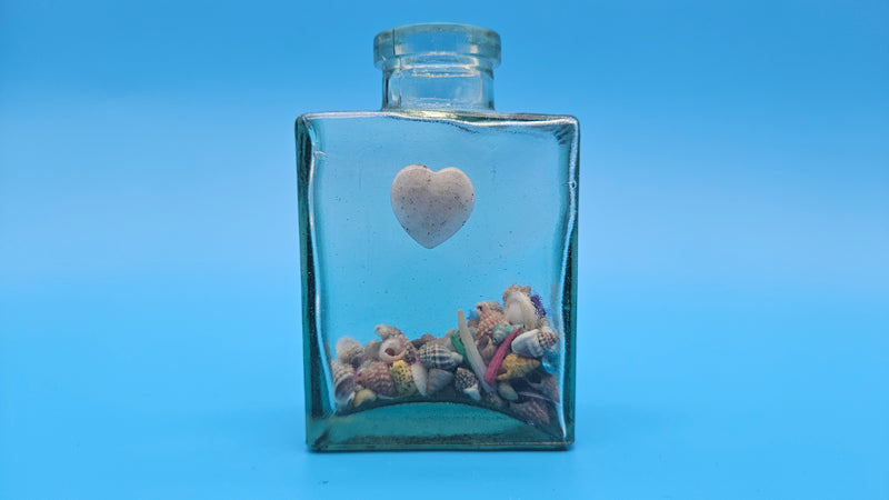 Vintage-style glass bottle with shell fill and heart charm – seaside decor