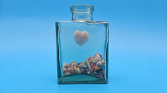 Vintage-style glass bottle with shell fill and heart charm – seaside decor