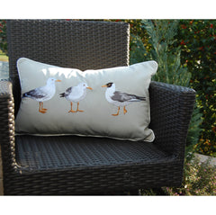 Seagull Indoor/Outdoor Pillow displayed on a wicker chair, highlighting its durable fabric and coastal-inspired design.