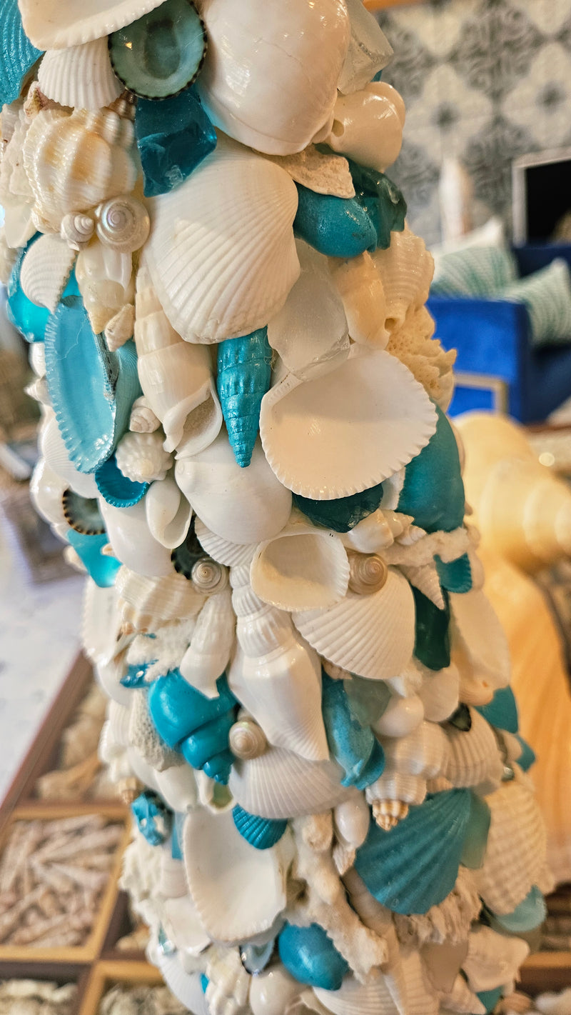 Close-up texture shot of the seashell tree, focusing on the individual white clam shells and pieces of vibrant blue shell fragments.