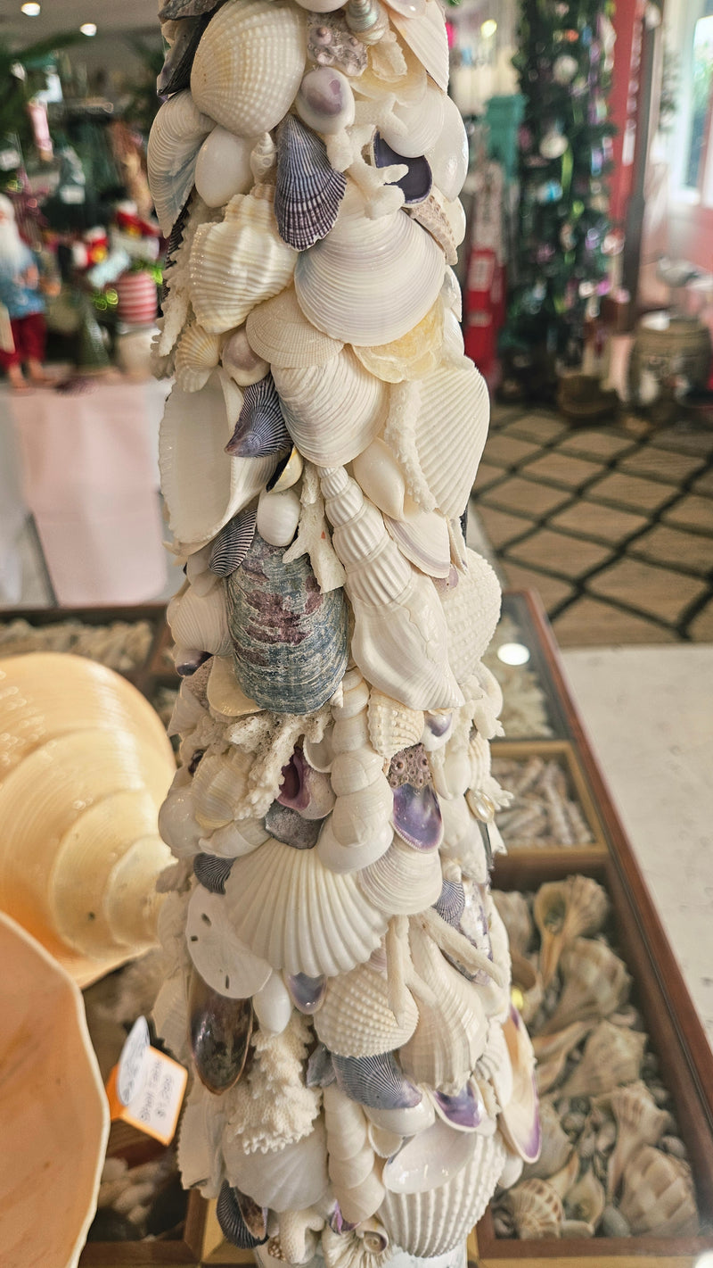Close-up of the seashell Christmas tree midsection, showing layers of natural white and pale lavender shells glued to the cone shape.