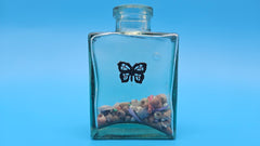 Shell-filled decorative bottle with etched butterfly design – coastal beach house decor