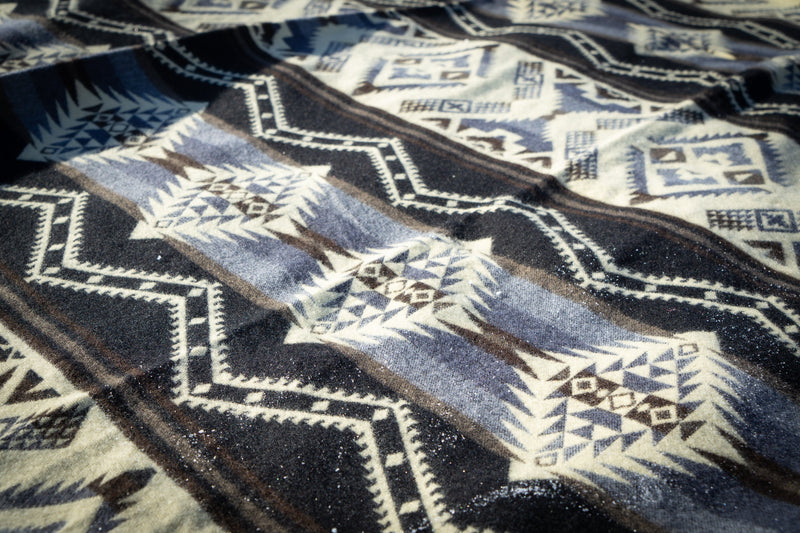 Detailed shot of the Slate gray and black geometric pattern spread flat on the snow, emphasizing the diamond motifs.