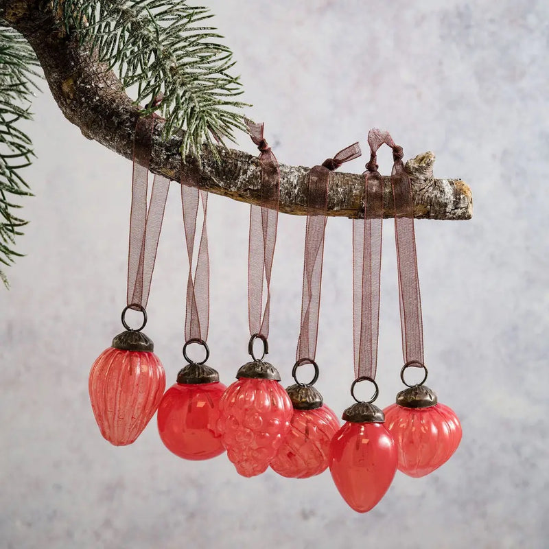 Small mixed design 1" peach luster glass baubles with semi-transparent peach-colored finish, hanging on a branch.