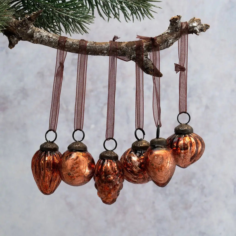 Small Mixed Design 1-inch Russet Crackle Glass Christmas Baubles hanging on a tree branch, available in six different designs, each sold individually.