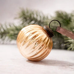 Champagne round ribbed glass Christmas ornament with bronze cap and organza ribbon.