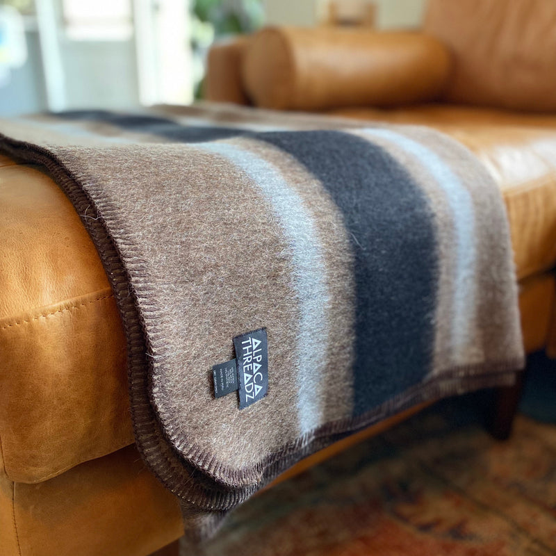 Brown and black alpaca throw draped over leather chair