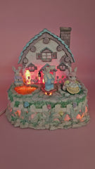 Vintage ABC Easter bunny cottage figurine with lighted house, animated bunnies, and music box that plays 