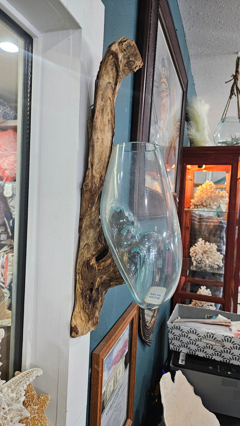 Wall-hanging teak wood and molten glass terrarium. Handcrafted design with molten glass fused to a natural teak wood base, creating a unique and rustic aesthetic. Perfect for displaying plants, flowers, or decorative items