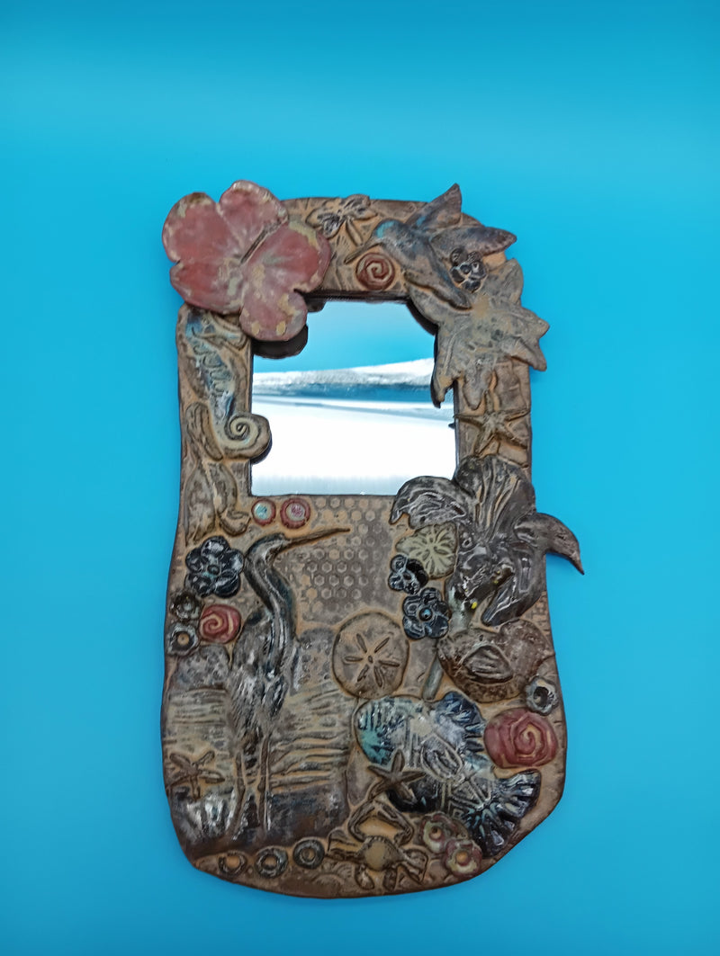 Handmade ceramic coastal mirror with hibiscus, heron, shells, and sand dollar – 13.5" x 8"