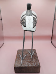 Hand-carved wooden avocet bird sculptures with black and white detailing on rustic stands