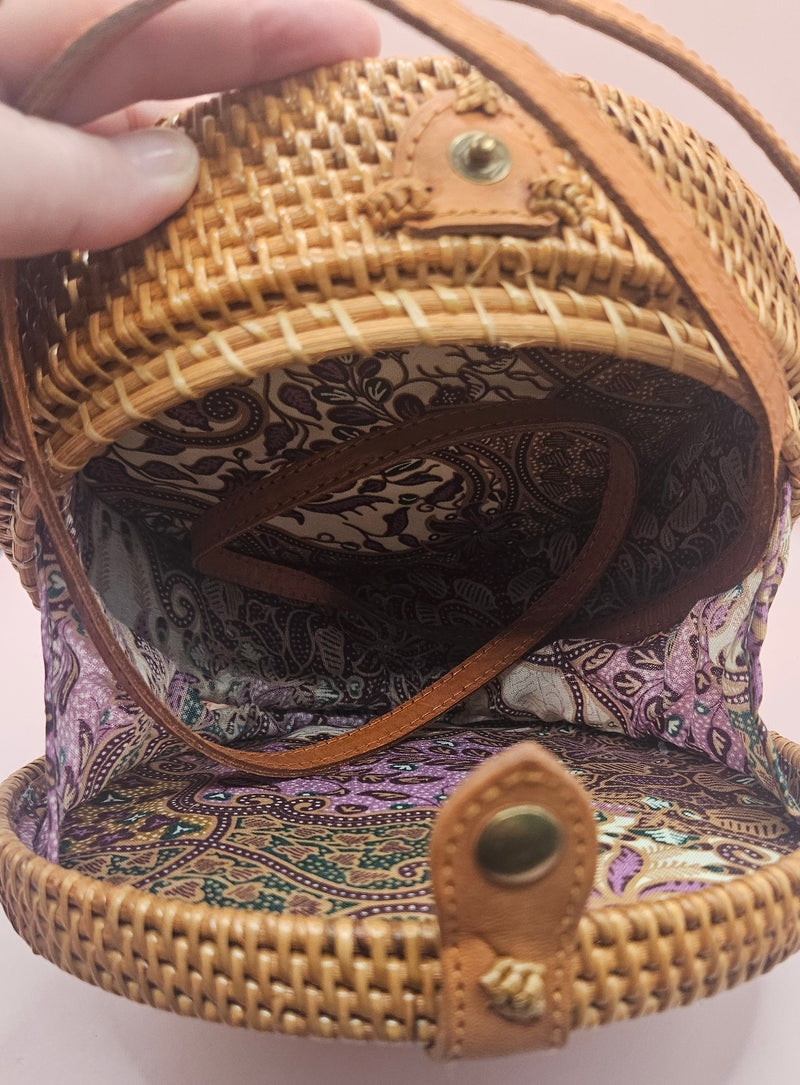 Round rattan crossbody bags in 4 styles—natural, pink, whitewash, and floral weave—with fabric-lined interior