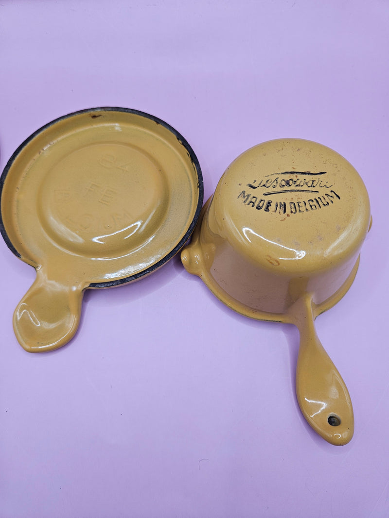 Vintage mustard yellow Descoware butter warmer with lid and trivet, cast iron design.