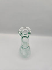 Vintage teardrop-shaped glass bottle, 7 inches tall by 2 inches wide, clear glass, perfect for décor or as a small vase.