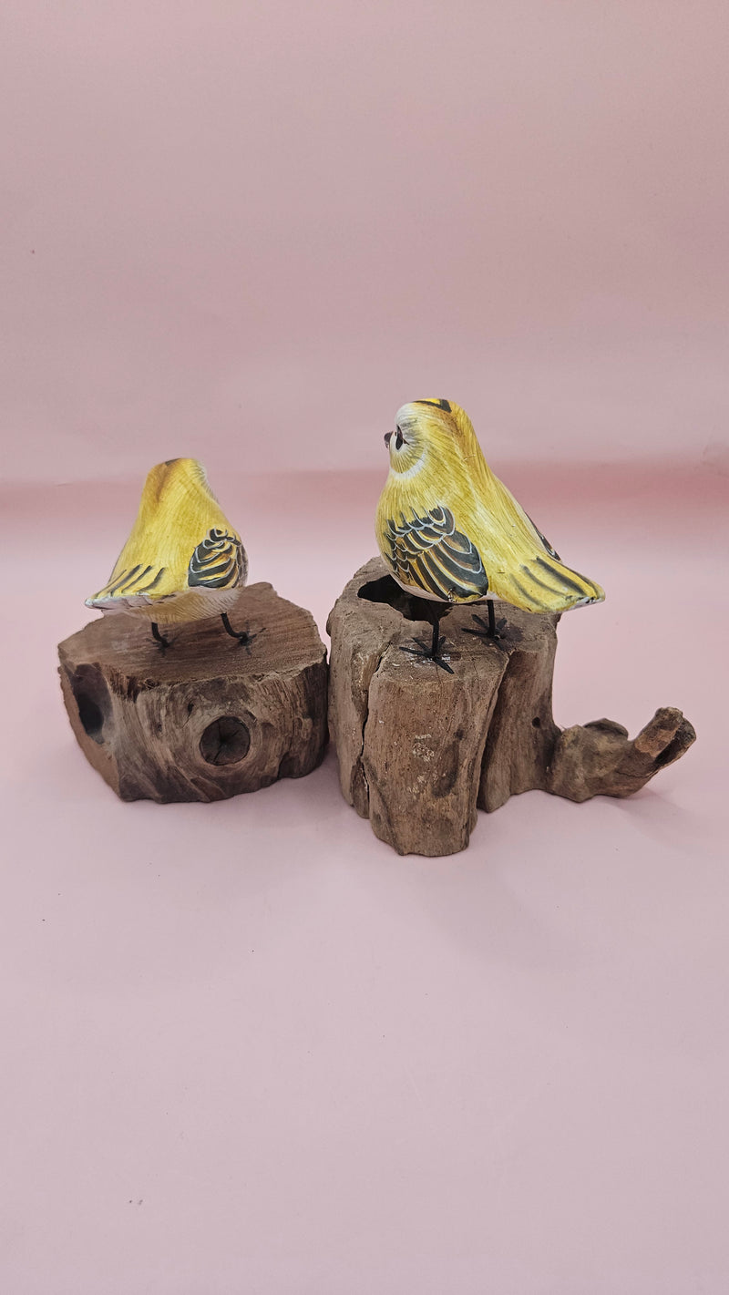 Hand-painted yellow bird figurine on wood stump with pink background – rustic handmade bird decor