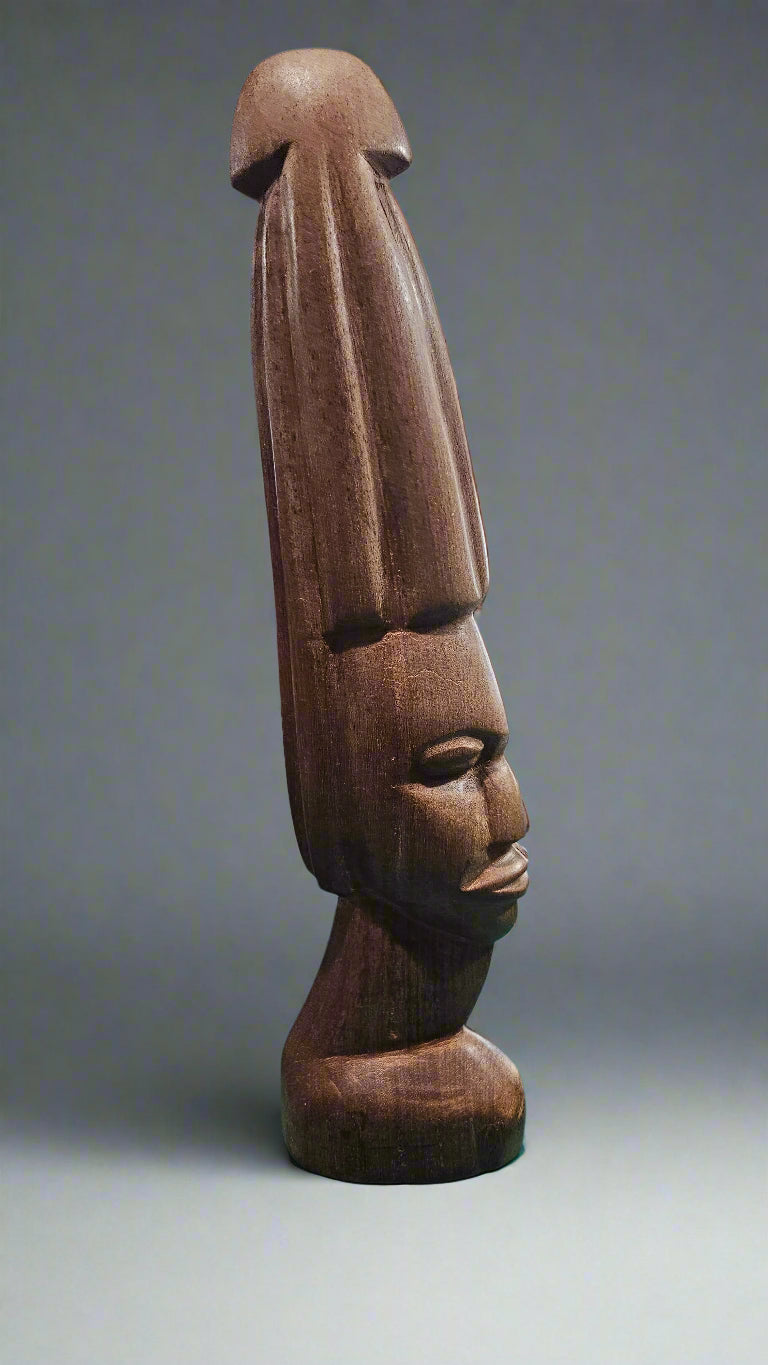 Vintage African tribal statue, hand-carved from solid wood, featuring an elongated headdress and serene facial expression.