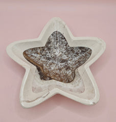 Dark polished onyx star dish with gray and brown veining on pink background