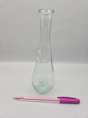 Vintage teardrop-shaped glass bottle, 7 inches tall by 2 inches wide, clear glass, perfect for décor or as a small vase.