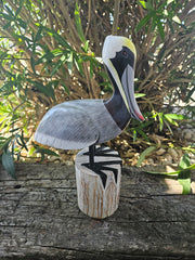 Carved wooden pelican decor in three sizes, small (11.5 x 7 inches), medium (14 x 9.5 inches), and large (17.75 x 11 inches), perfect for coastal decor