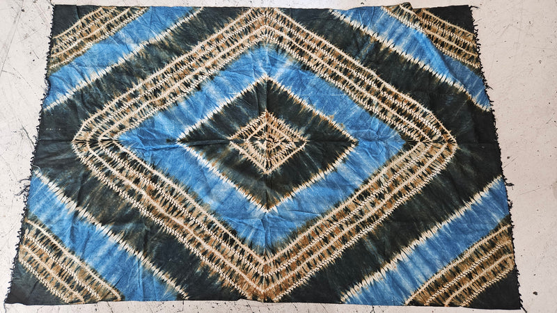  A vintage African handwoven tapestry with indigo blue and earthy brown tie-dye geometric patterns, measuring 65"x42.5"