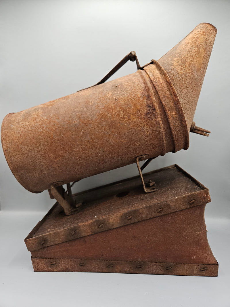 A vintage metal beekeeping smoker with a cone-shaped spout and rectangular body. The piece has a rustic, aged patina with visible rivets, making it a unique collectible or décor item for vintage and industrial-themed spaces