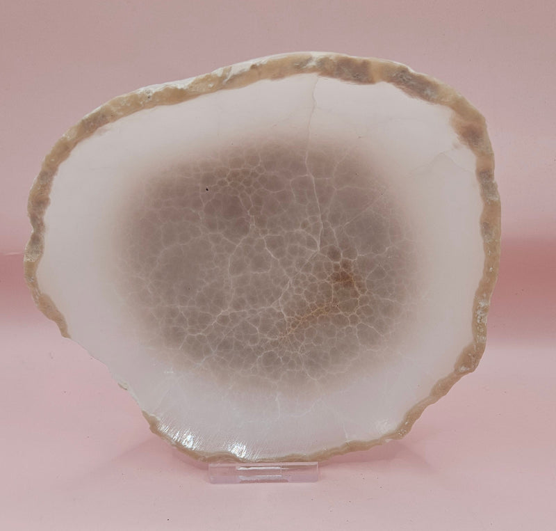 small raw-edge onyx dishes with soft cream coloring and polished finish on pink background