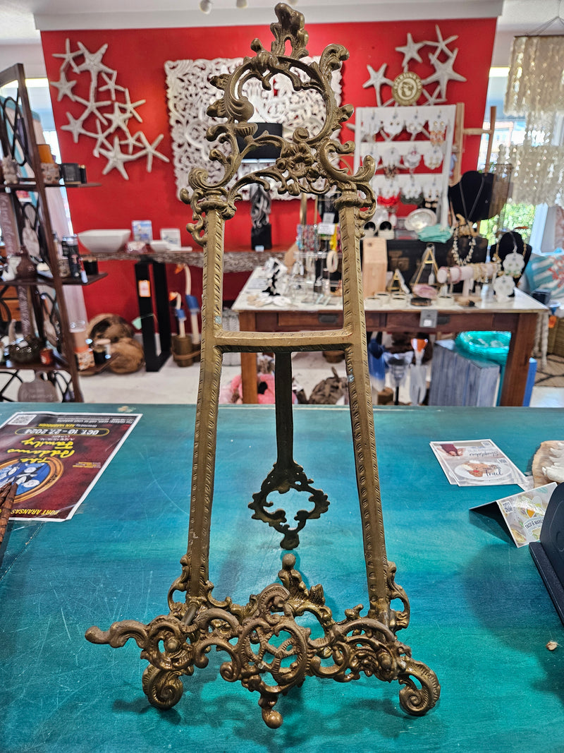 A 21.5" tall vintage gilded brass ornate easel with intricate detailing, ideal for displaying artwork, photographs, or decorative items.