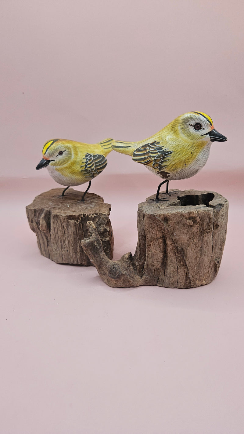 Hand-painted yellow bird figurine on wood stump with pink background – rustic handmade bird decor