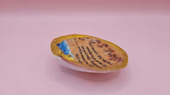 Handmade decorative shell with “Footprints” poem text, beach wave design, and golden painted rim, shown held in a hand.