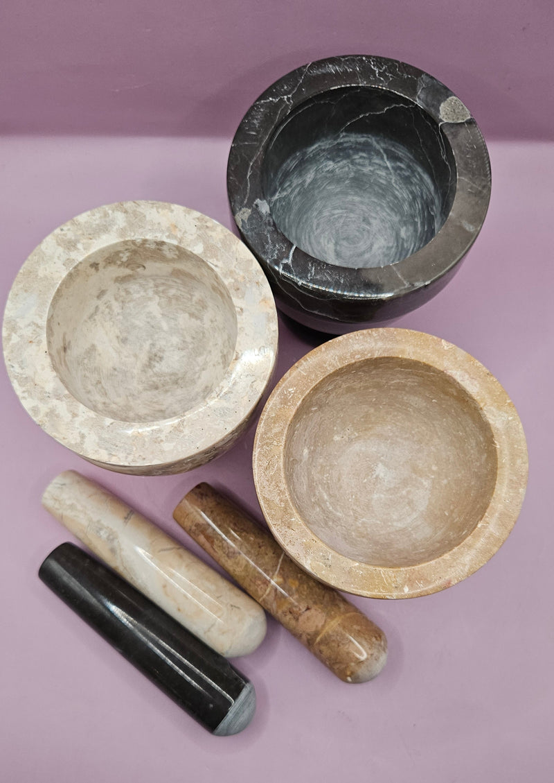 Three stone mortar and pestle sets in beige, brown, and black, featuring a durable design for grinding spices and herbs.