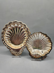 A close-up of two vintage silver-plated scalloped trays, showcasing their reflective finish and elegant, curved edges. Trays come in two sizes, 4.5