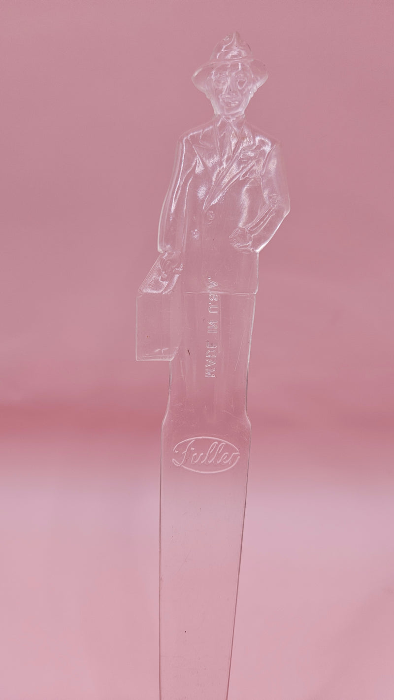 Vintage clear plastic Fuller Brush Man letter opener, shaped like a businessman holding a briefcase, measuring 7.25 inches long.