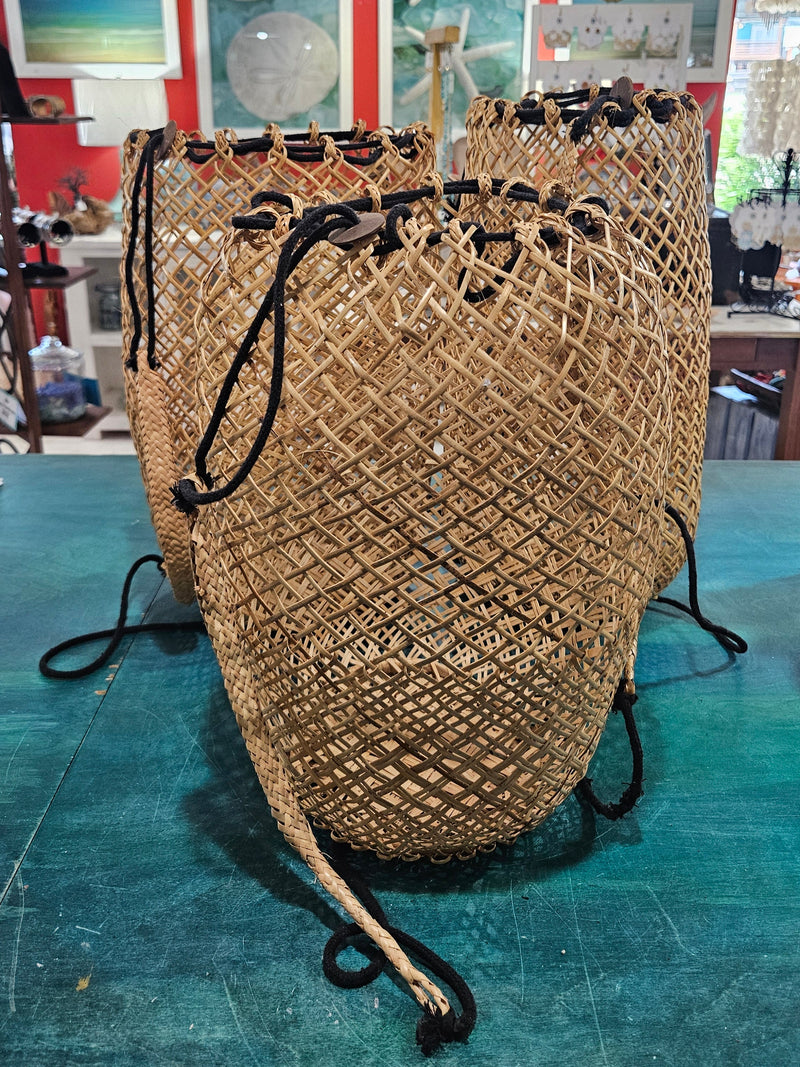 handwoven rattan backpack basket with natural braided straps and open lattice pattern 