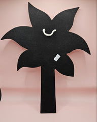 Handmade palm tree wall art made of natural white shells with beaded detailing on a pink background.