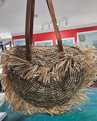 Handwoven round 16-inch straw tote bag with fringe and leather handles