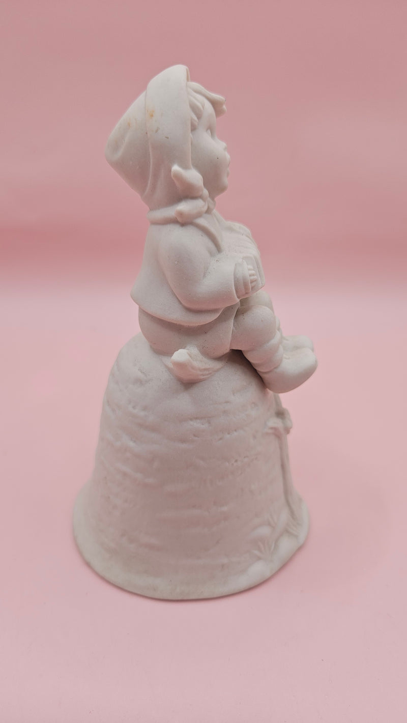 Unpainted vintage ceramic bisque bell featuring a boy with accordion sitting on a tree with bird detail, Provincial Mold #P-447, 4.8x2.8 inches.